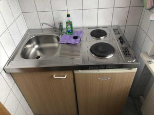 a small kitchen with a sink and a stove at Ferienwohnung Sprenger _ Objekt 25 in Rostock +3 photos