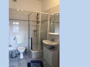 La salle de bains est pourvue de toilettes, d'un lavabo et d'une douche. dans l'établissement Ferienwohnung Sprenger _ Objekt 25, à Rostock