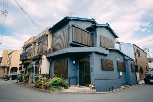 a blue building with a dog sitting in front of it at Tofukuji Saku Inn（东福寺咲く宿） in Kyoto