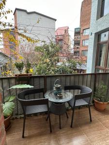 eine Terrasse mit 2 Stühlen und einem Tisch auf dem Balkon in der Unterkunft Sun Apartment in Tbilisi City