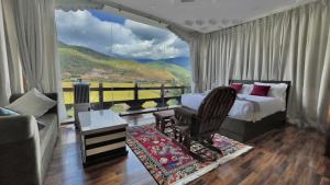 ein Schlafzimmer mit einem Bett und ein Zimmer mit Aussicht in der Unterkunft Zhideychen Resort in Paro