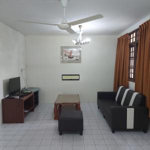 a living room with a couch and a tv at Shang Homestay Miri in Miri