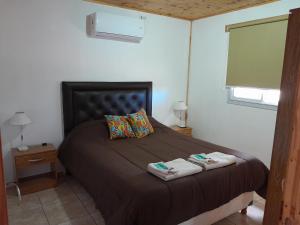 1 dormitorio con 1 cama con 2 toallas en Cabañas Cañones del Triásico en Villa Unión