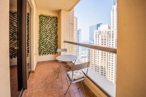 - Balcón con mesa y sillas en un edificio en Cozy 2 BD in Bahar JBR 24 floor, en Dubái
