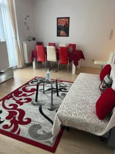 a living room with a table and red chairs at 3C-Apartments in Ghent