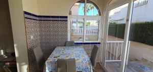 d'une salle à manger avec une table, des chaises et une fenêtre. dans l'établissement Ferienwohnung Torrevieja, à Torrevieja