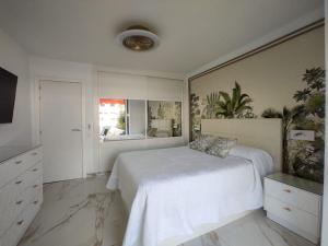 a white bedroom with a bed and a mirror at PARQUE SANTIAGO I Stunning brand new apt 2 bedroom Playa de las Américas in Playa de las Americas