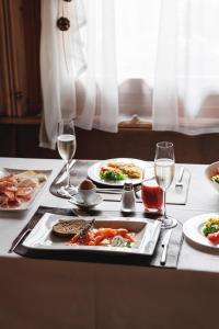a table with plates of food and glasses of wine at Camana Veglia in Livigno
