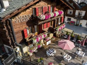 an overhead view of a building with flowers and tables and an umbrella at Camana Veglia in Livigno