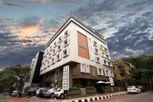 a building with cars parked in front of it at Akash Inn in Shimoga