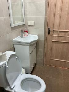 baño con aseo, lavabo y puerta en Дом рядом проспекта Исакова, 3 км Звартноц аэропорт EVN, en Geghanist