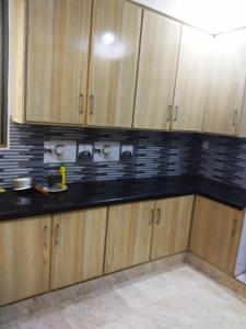 a kitchen with wooden cabinets and black counter tops at Continental Girls Hostel UCP in Lahore