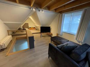 ein Wohnzimmer mit einem Sofa und einem TV in der Unterkunft B&B Het KoeKoeKsnest Schelle in Schelle