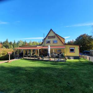 a building with a fountain in front of a yard at B&B Waldcafe in Altenau