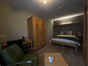 1 dormitorio con cama, sofá y mesa en B&B Het KoeKoeKsnest Schelle en Schelle