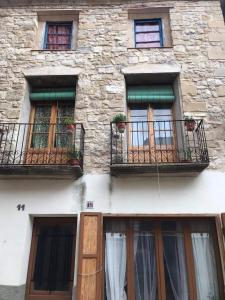 a stone building with two windows and two balconies at Sidharta Room in Villalba dels Arcs