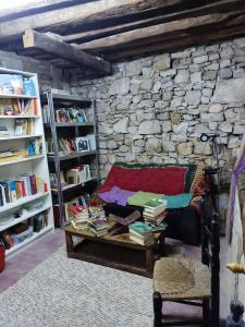 a room with a couch and books on a table at Sidharta Room in Villalba dels Arcs