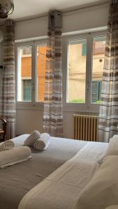 una camera da letto con un letto con due cuscini e due finestre di RiverView city apartment a Verona