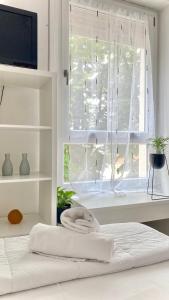 um quarto branco com uma janela com uma toalha numa cama em RiverView city apartment em Verona
