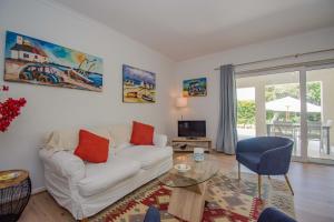 a living room with a white couch and a glass table at Garden- Pool flat with Solar Electricity in Somerset West