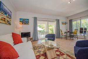 a living room with a white couch and a table at Garden- Pool flat with Solar Electricity in Somerset West