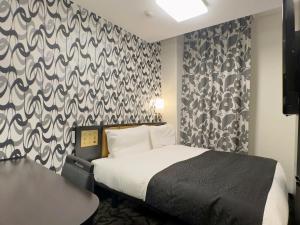 A bed or beds in a room at APA Hotel Osaka Kadomashi Ekimae