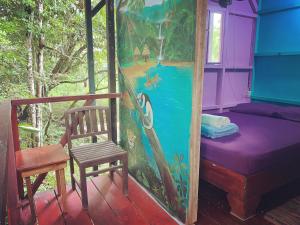 una casa con una silla y una pintura en la pared en Hidden Jungle Beach House, en Puerto Viejo