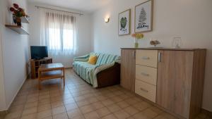 a living room with a couch and a television at Apartments Đoković in Rab