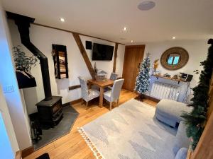 a living room with a table and a wood stove at Apple Tree Cottage - Cosy 2 Bed with Deluxe HOT TUB & Log Burner in Hereford