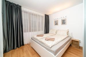 a bedroom with a bed and a large window at Cozy Stay 2bdrm Central Apartment in Varna City