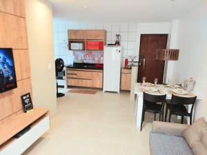 馬塞約的住宿－Apartamento Vernazza Jatiuca，厨房以及带桌子和冰箱的用餐室