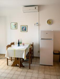 Il comprend une cuisine équipée d'une table et d'un réfrigérateur. dans l'établissement Apartments Đoković, à Rab