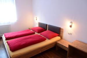 a bed with red pillows on it in a room at Haus Fulterer in Siusi
