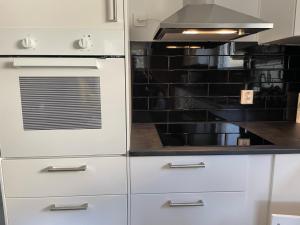 a kitchen with white cabinets and a stove at Villa med 5 sovrum in Gothenburg
