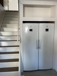 a white refrigerator in front of a staircase at Villa med 4 sovrum in Gothenburg