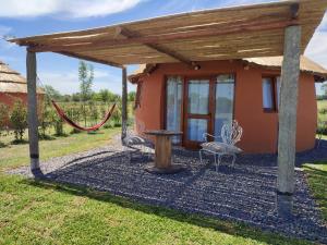 Casa pequeña con pérgola, mesa y sillas en Tierra de Inmigrantes en Baradero