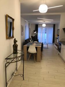 ein Wohnzimmer mit einem Sofa und einem Tisch mit einem Stuhl in der Unterkunft Alsacian Home - Old Town Cosy Apartments in Colmar