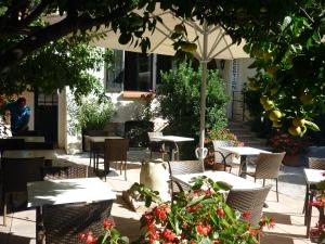 an outdoor patio with tables and chairs and an umbrella at La Marjolaine in Juan-les-Pins