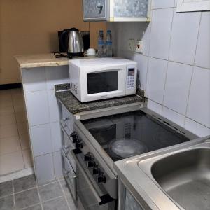 a kitchen with a microwave on top of a stove at Al Nakheel Hotel Apartments in Dubai