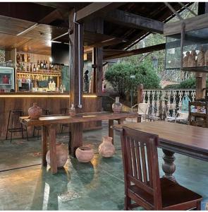 a bar with a large wooden table and chairs at Pousada Canto da Lua in Nova Lima