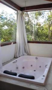 a bath tub in a room with a window at Pousada Canto da Lua in Nova Lima