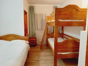 a bedroom with two bunk beds and a bed at Vila Esperia Rânca in Ranca