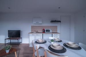 a living room with a table with chairs and a kitchen at Le Scandinave - Tarbes centre in Tarbes +3 photos