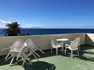 eine Gruppe Stühle und ein Tisch auf dem Balkon in der Unterkunft Apartamentos Concha in Valle Gran Rey