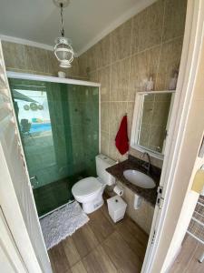 ein Badezimmer mit Toilette, Waschbecken und Spiegel in der Unterkunft Casa Águas de São Pedro in Águas de São Pedro