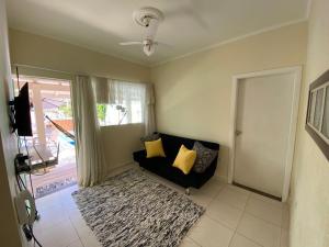 a living room with a couch and a window at Casa Águas de São Pedro in Águas de São Pedro