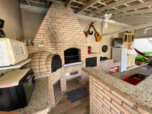 a kitchen with a brick oven in the middle at Casa Águas de São Pedro in Águas de São Pedro