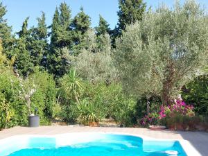 einen Pool in einem Garten mit Bäumen in der Unterkunft Defneland Daphne in Ildır