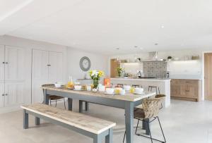 - une cuisine avec une table et des chaises dans la chambre dans l'établissement Stone Barn, contemporary barn conversion, à Cheltenham