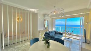 Sala de estar con sofá azul y vistas al océano en « LA SUITE »Superbe appartement NEUF, Front de mer, en Menton